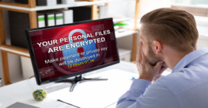 Worried businessman looking at a ransomware message on his computer