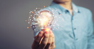 Man holding light bulb, demonstrating innovative technology and creativity.
